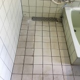 クリーニング前の白いタイルの浴室